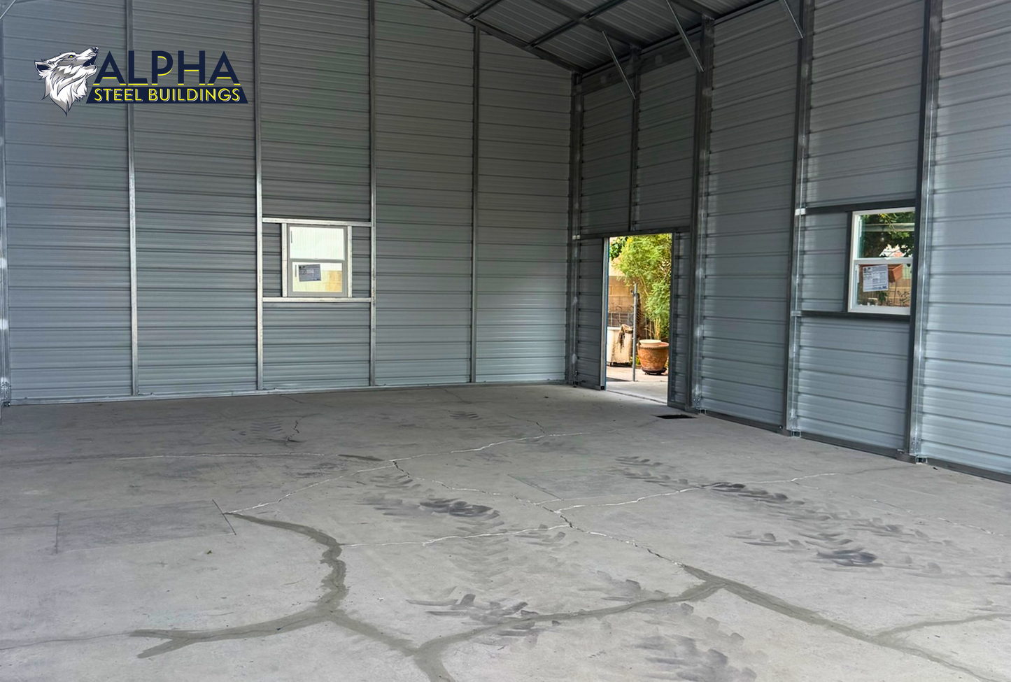 Interior of a 30'x50'x12' continuous roof barn style steel building featuring a spacious open floor plan, vertical roof, enclosed walls, walk-in door, and window.