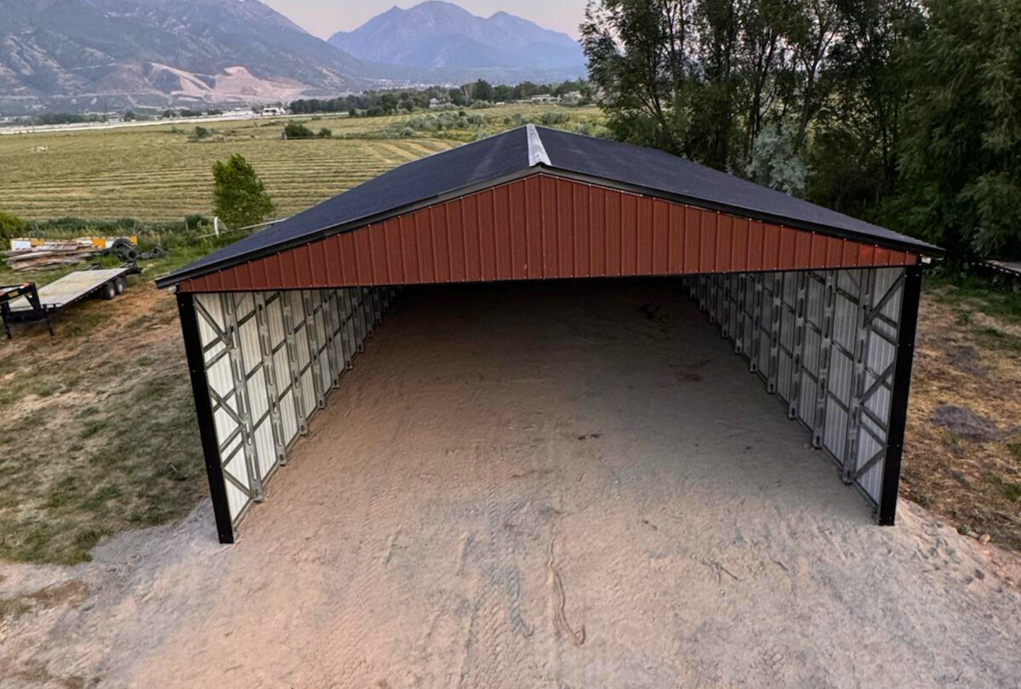 Outside front view of 36'x80'x14' steel hay shop features ladder style truss design, vertical roof, 14 Ga. frame, 40PSF ground snow load, both sides, back end & front gable end enclosed with vertical siding, lateral & back end diagonal bracing.