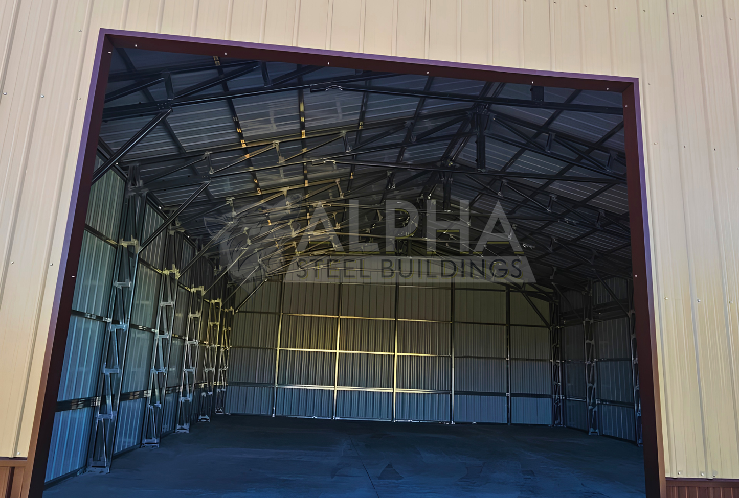 Close up front view of 56'x45'x14' clear span building with main section & dual lean-tos. Features web truss design, vertical roof, 14 Ga. frame, 40PSF ground snow load, fully enclosed with vertical siding, one walk-in door, and frame outs for one 12' x 12' overhead door and one 10' x 10' overhead doors on the front end.