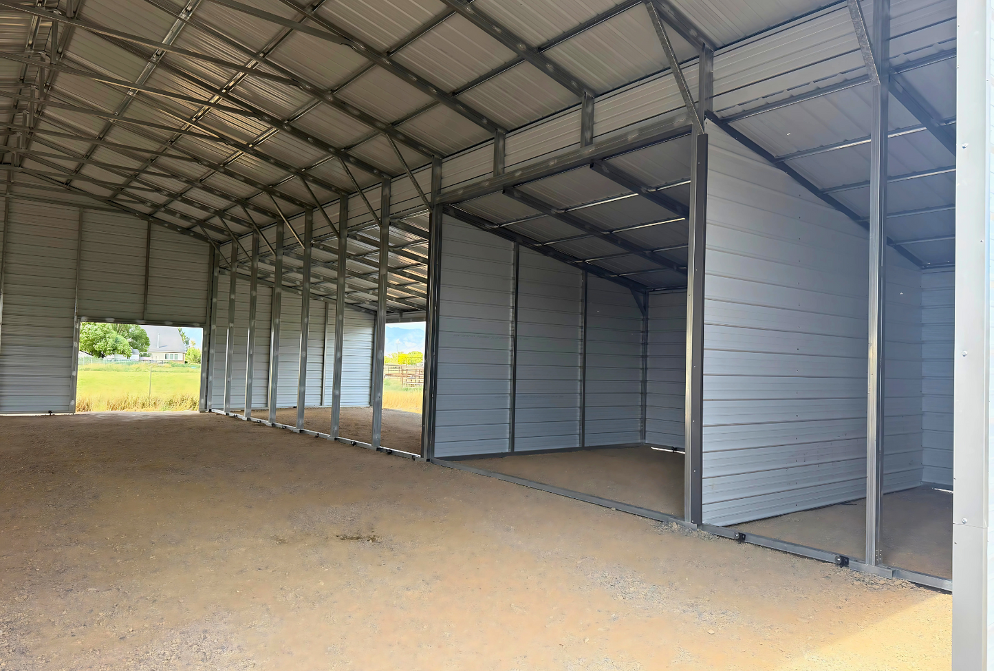 60'x60'x14' down to 12'-9' steel barn style with lean-tos, two panels under the eave, both sides closed, all ends closed, with 12' x 15' wash bay, (1) 12' x 13' frame out on the end, (1) 9' x 7' frame out on the end, (1) 14'2" x 12' wash bay frame out on the side, (4) 9'2" x 8' stall frame outs on the side of left lean-to, (2) 14'2" x 8' frame outs on the side of right lean-to, (1) 36" x 80" walk-in door, right inside view.