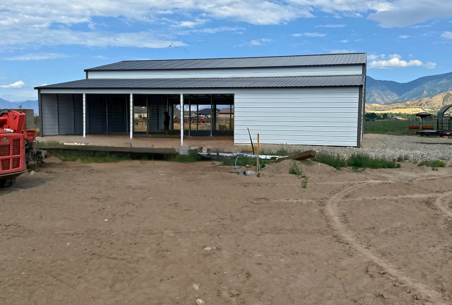 60'x60'x14' down to 12'-9' steel barn style with lean-tos, two panels under the eave, both sides closed, all ends closed, with 12' x 15' wash bay, (1) 12' x 13' frame out on the end, (1) 9' x 7' frame out on the end, (1) 14'2" x 12' wash bay frame out on the side, (4) 9'2" x 8' stall frame outs on the side of left lean-to, (2) 14'2" x 8' frame outs on the side of right lean-to, (1) 36" x 80" walk-in door, left view.