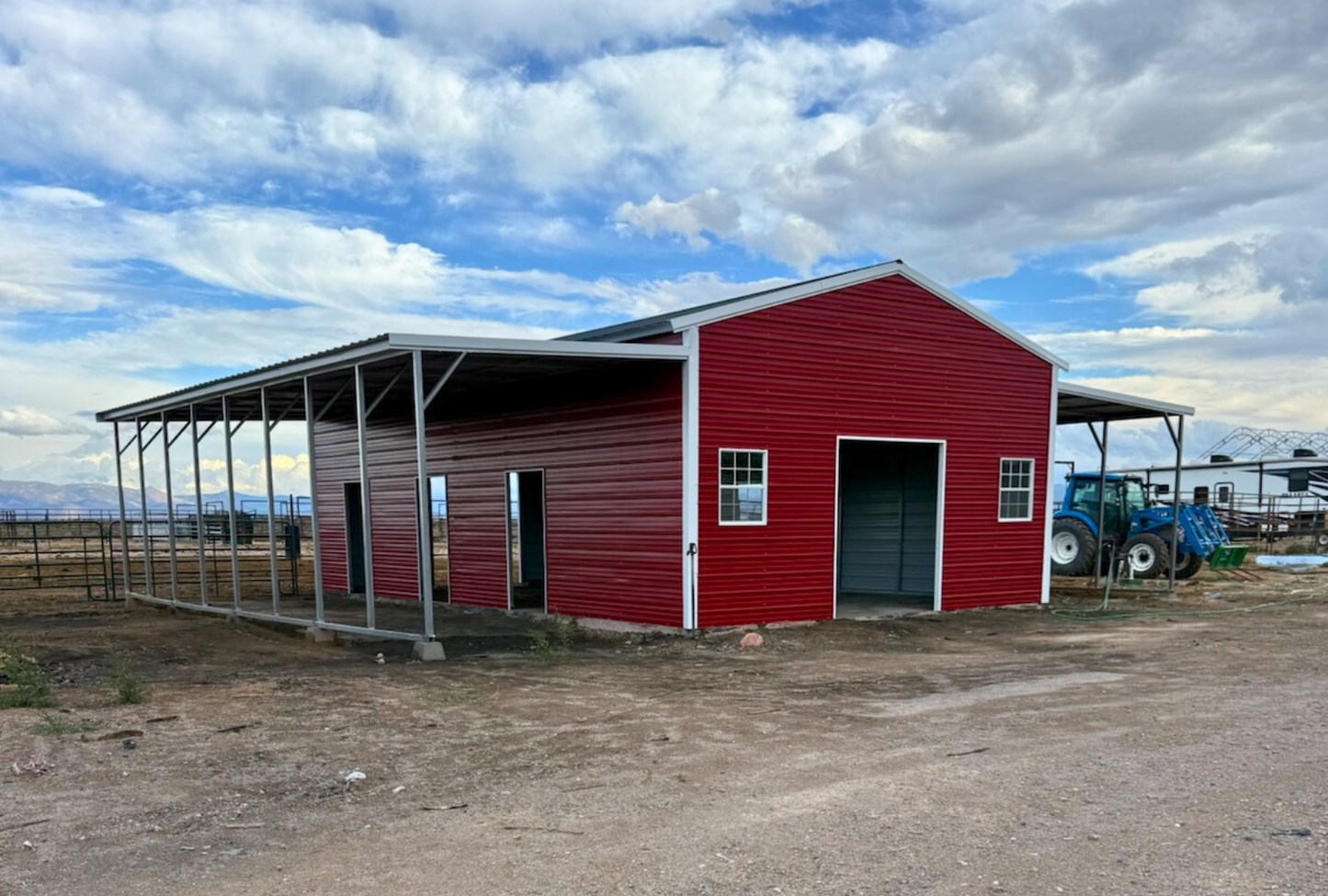 Front left angled view of a 48x40 metal barn with dual 12-foot lean-tos, vertical roof, two 7x8 overhead door frame-outs on each end, and 4x8 sliding doors on both sides.