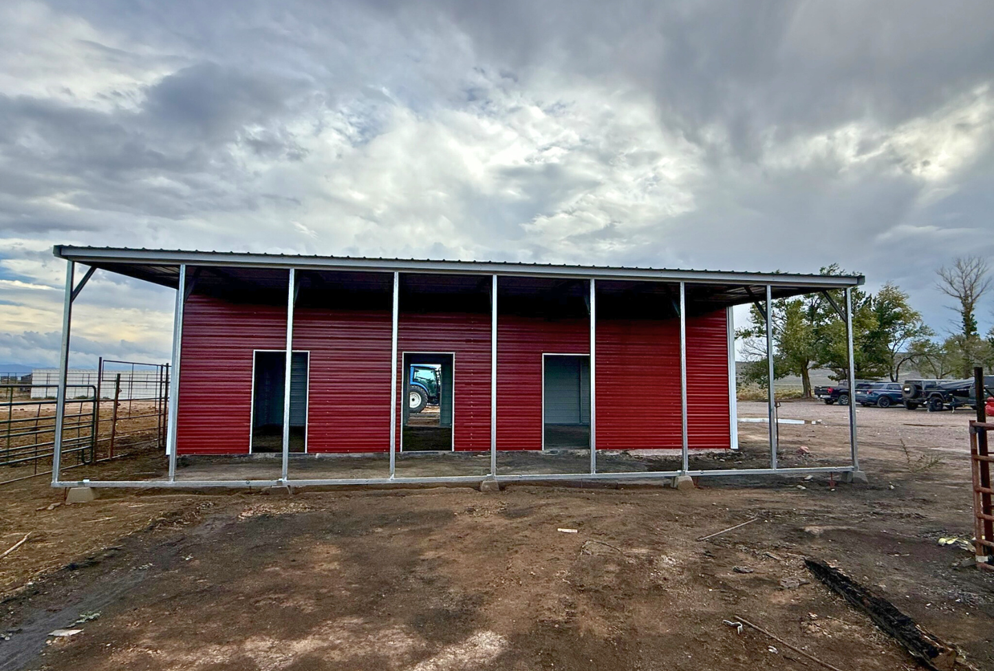 Left side view of a 48x40 steel barn from Alpha Steel Buildings with two 12-foot-wide lean-to's, vertical roof panels, closed sides, and 4x8 sliding door openings.