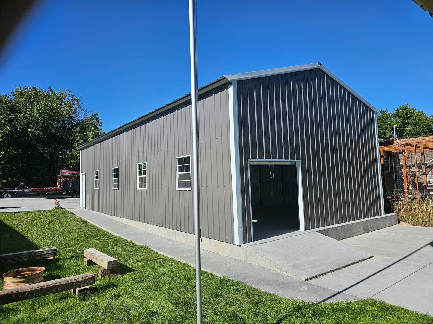 22'x48'x12' A-frame vertical roof garage with 14 Ga. frame, 40PSF ground snow load, fully enclosed, featuring one 6' x 6' roll-up door on back end, four 30" x 36" windows, one 36" x 80" walk-in door, one 20' x 10' overhead door frame out on front end, and thirty-eight 1/2" concrete bolts.