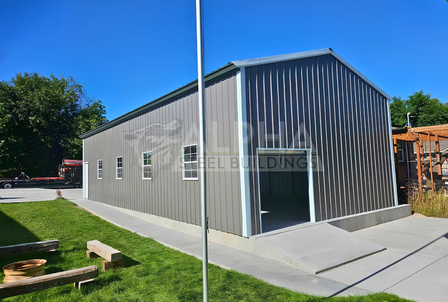 Rear view of 22' x 50' x 12' steel garage featuring a 20' x 10' overhead door frame out, one 6' x 6' roll-up door on the back, four windows and one walk-in door.