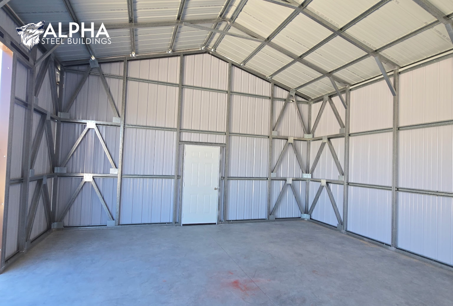 Interior view of 22x60x12 A-frame utility building showing steel framing, vertical wall panels, cross bracing, and walk-in door.