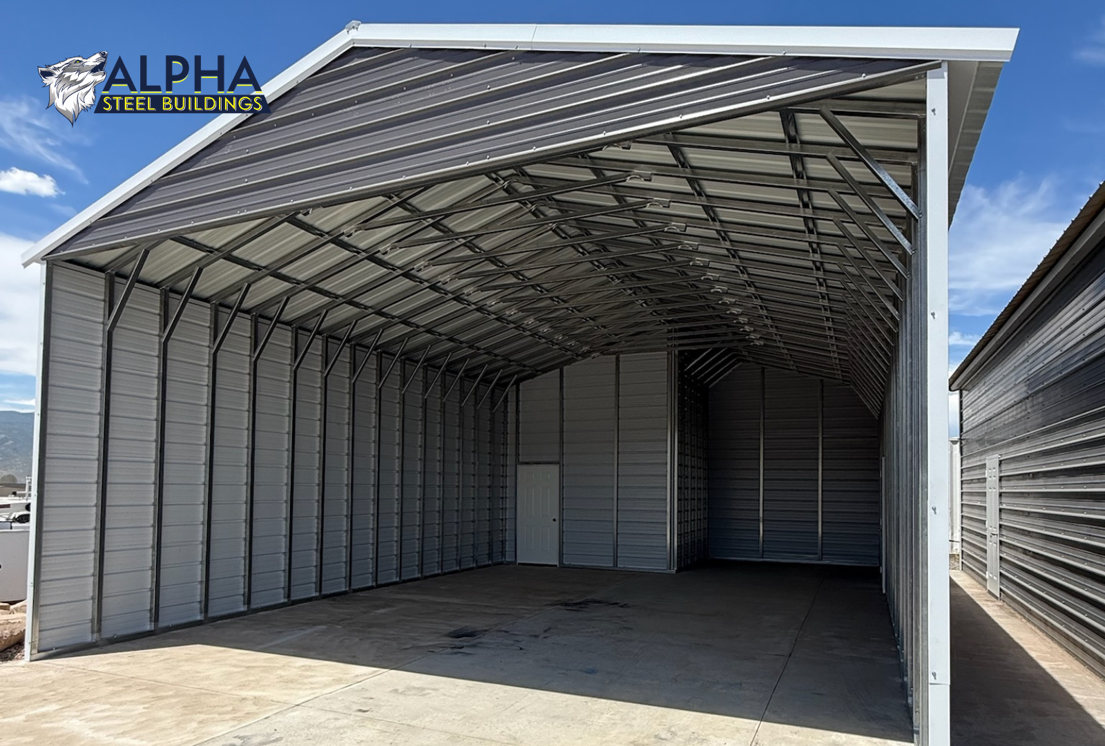 24'x30'x12' vertical roof steel utility building with enclosed sides, front gable end, walk-in door, and attached lean-to viewed from the front interior.