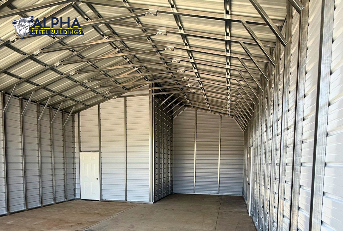 Interior of a 24'x30'x12' vertical roof steel utility building featuring enclosed storage space, 14-gauge steel framing, vertical roof panels, and a walk-in door.