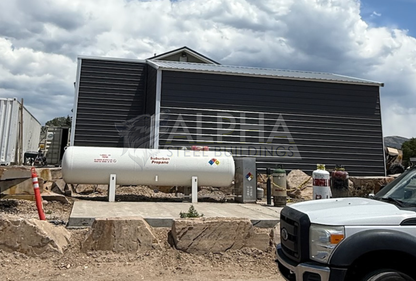 Side exterior view of a 24'x30'x12' vertical roof steel utility building with a 12'x10' attached lean-to, enclosed side walls, and vertical roof metal panels.