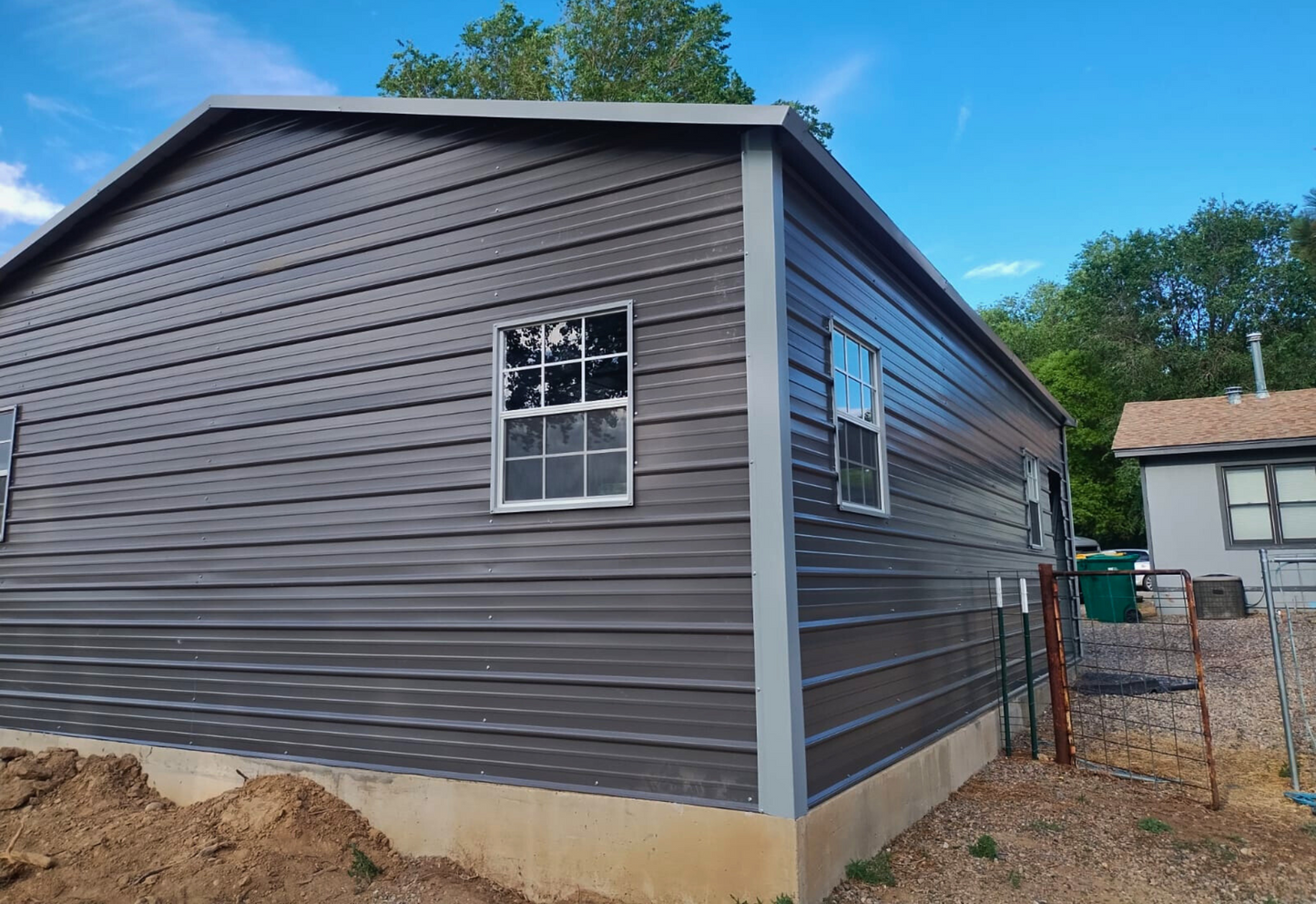 24'x30'x9' A-frame horizontal roof garage with 14 Ga. frame, 40PSF ground snow load, fully enclosed, featuring five 30" x 36" windows, one 36" x 80" walk-in door frame out, two 10' x 8' overhead door frame outs on front end, and thirty 1/2" concrete bolts.