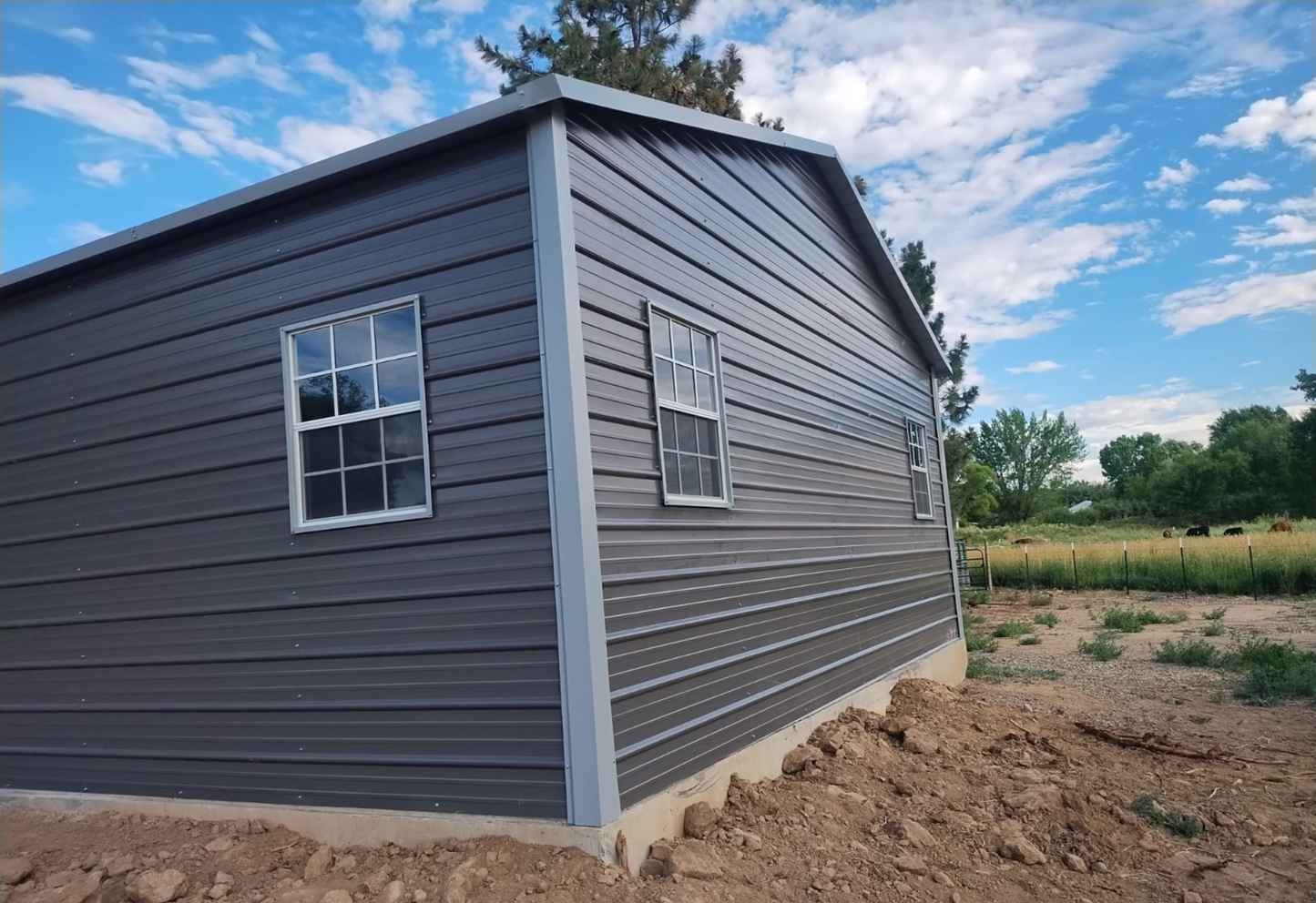 24'x30'x9' A-frame horizontal roof garage with 14 Ga. frame, 40PSF ground snow load, fully enclosed, featuring five 30" x 36" windows, one 36" x 80" walk-in door frame out, two 10' x 8' overhead door frame outs on front end, and thirty 1/2" concrete bolts.