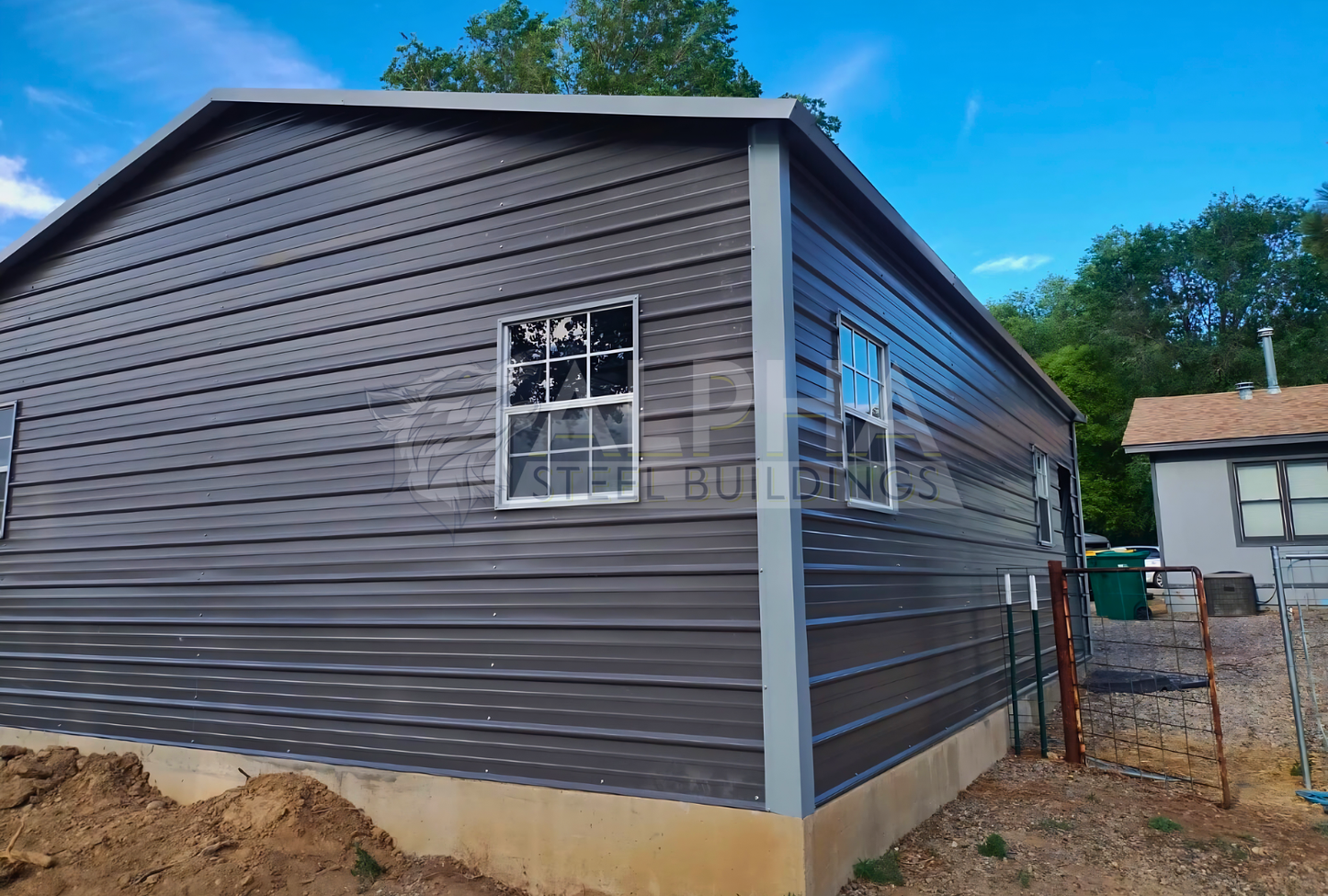 Rear right angled view of 24'x30'x9' A-frame horizontal roof garage, fully enclosed, featuring five windows, one walk-in door frame out, two overhead door frame outs on front end