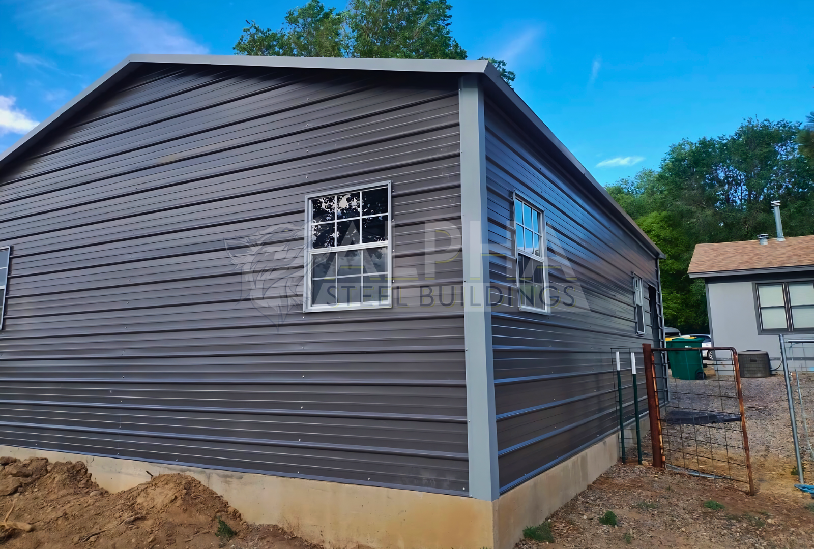 Rear right angled view of 24'x30'x9' A-frame horizontal roof garage, fully enclosed, featuring five windows, one walk-in door frame out, two overhead door frame outs on front end