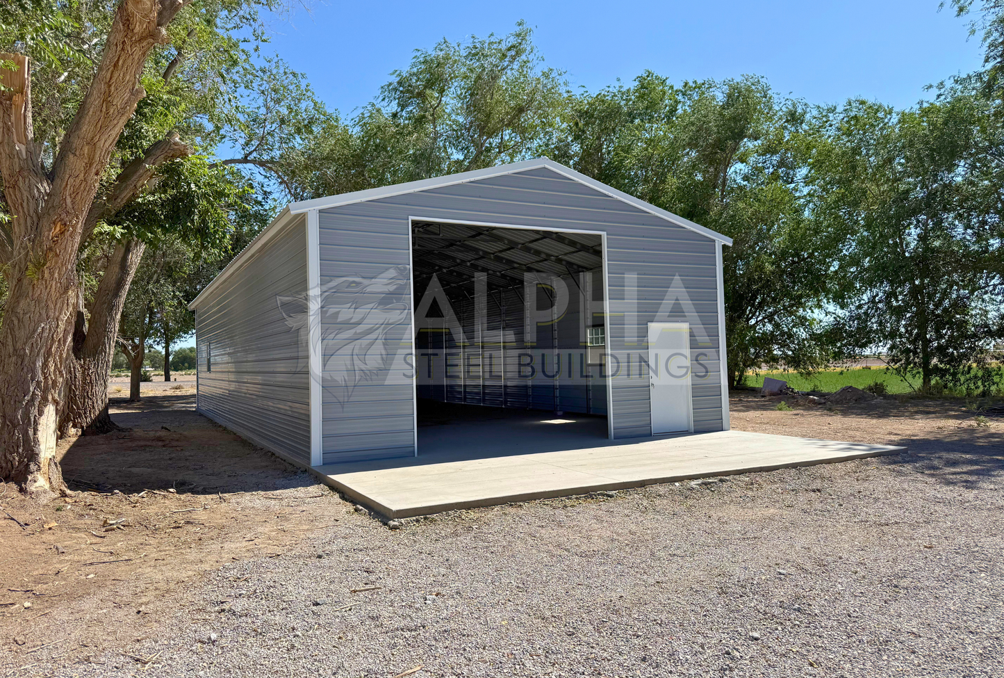 26x60x12 A-frame steel building with vertical roof, 12x12 overhead door frame-out, walk-in door and windows, front left angled view