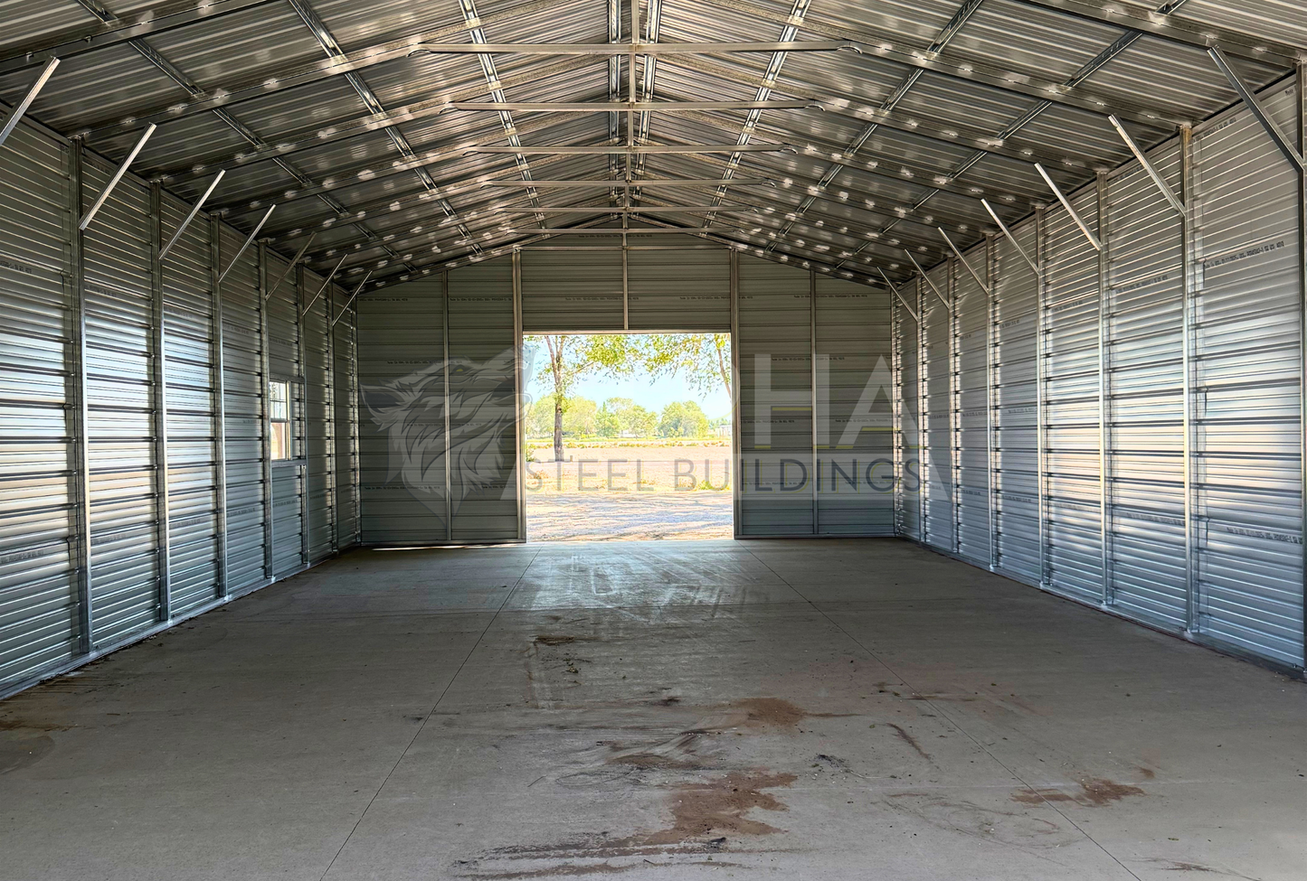 26x60x12 A-frame steel building with vertical roof, steel framing, horizontal panels and concrete floor, interior view