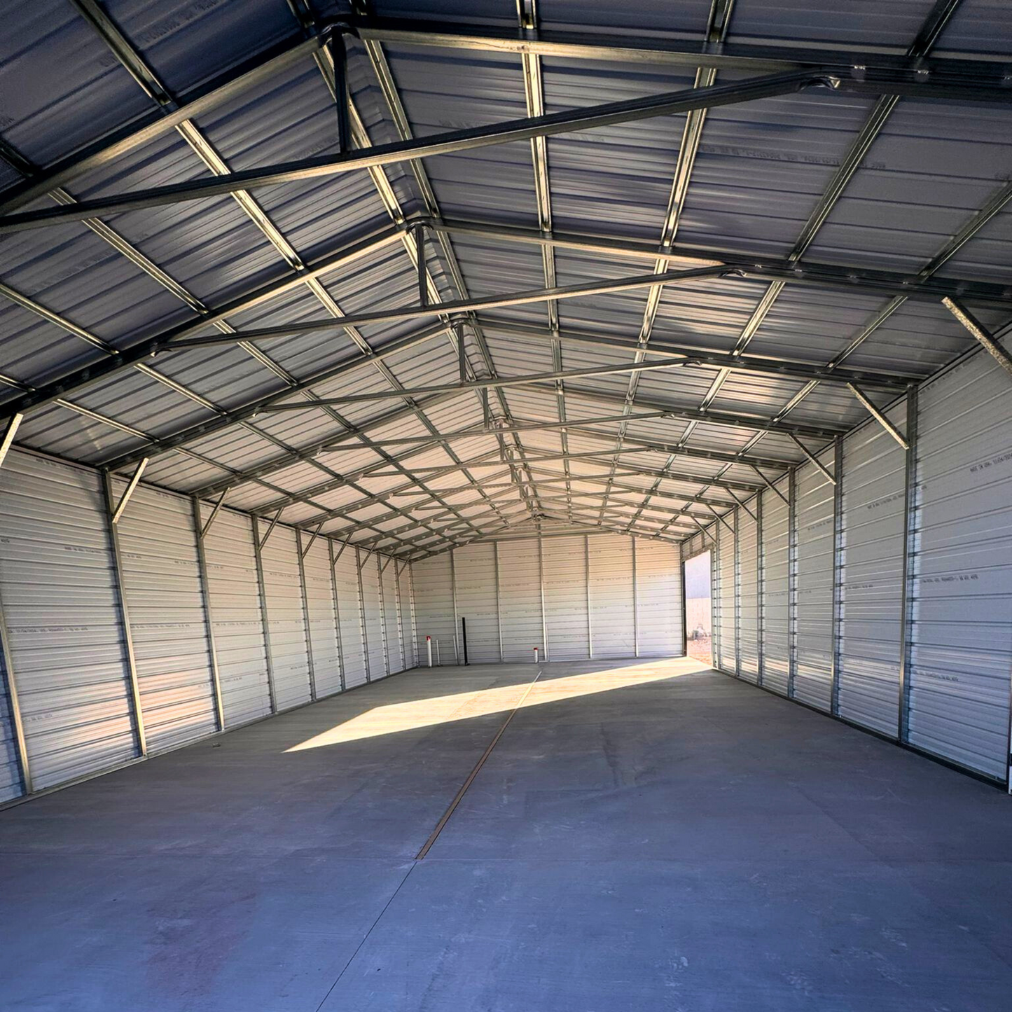 A-frame metal building with a vertical roof, fully enclosed on both sides and ends for secure storage and weather protection.