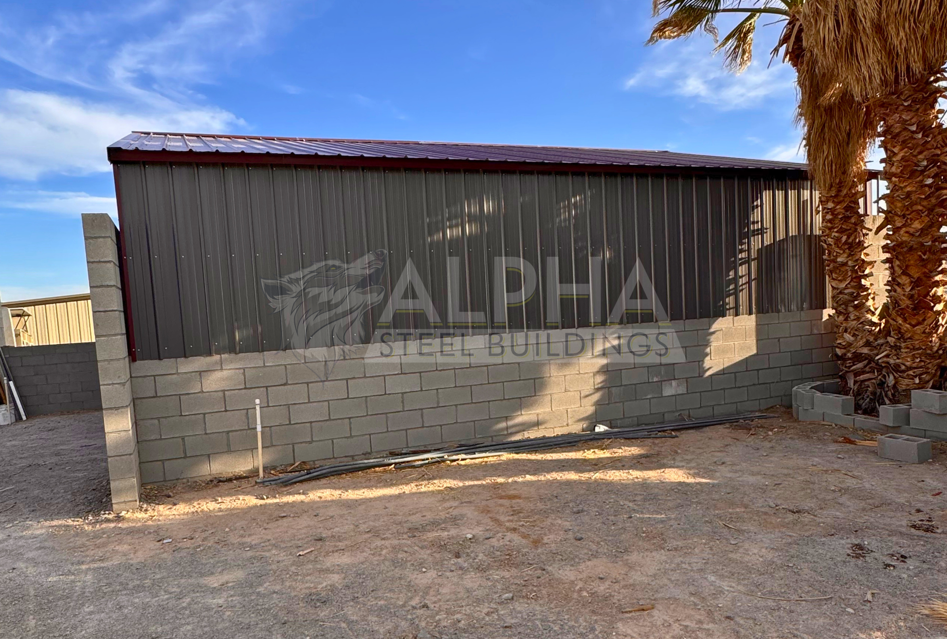 Side view of a 30x35x6 A-frame steel agricultural building showing vertical metal side panels installed above the existing block wall and the vertical roof