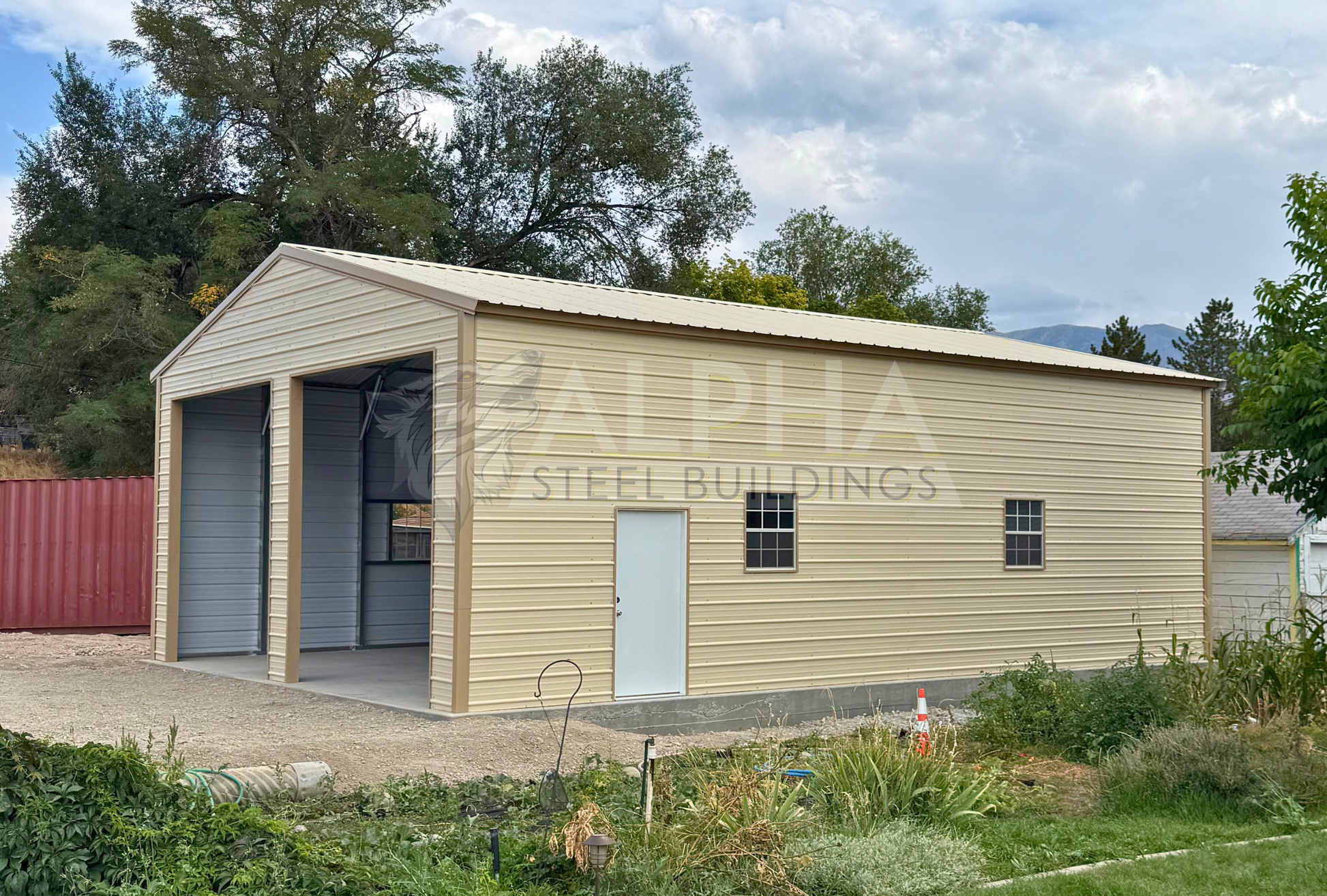 30x40x13 A-frame steel garage with vertical roof, (2) 12' x 12' overhead door frame outs on the end, 36" x 80" walk-in door and (2) 30" x 36" windows on the right side, front right angled view