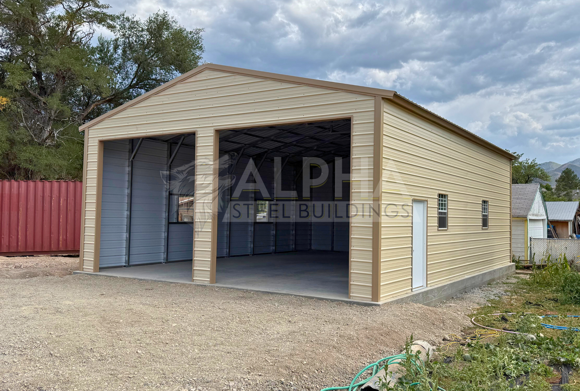 30x40x13 A-frame steel garage with vertical roof, (2) 12' x 12' overhead door frame outs on the end, with walk-in door and windows visible on the right side, front view at slight right angle