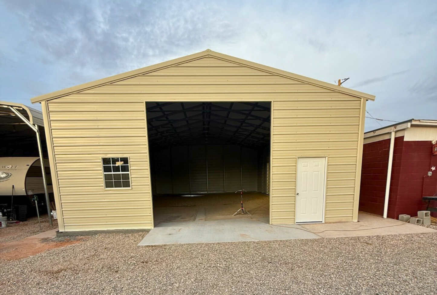Front view of a 30x45 A-frame steel building with vertical roof, 12-foot height, closed sides and ends, 12x12 overhead door frame-out, and walk-in doors
