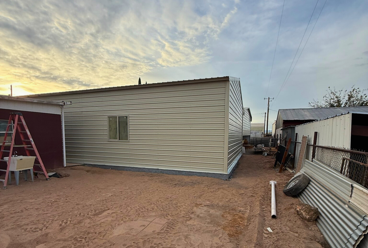 Left back angled view of a 30x45 steel building with A-frame design, vertical roof, fully closed sides and ends, and framed window openings.