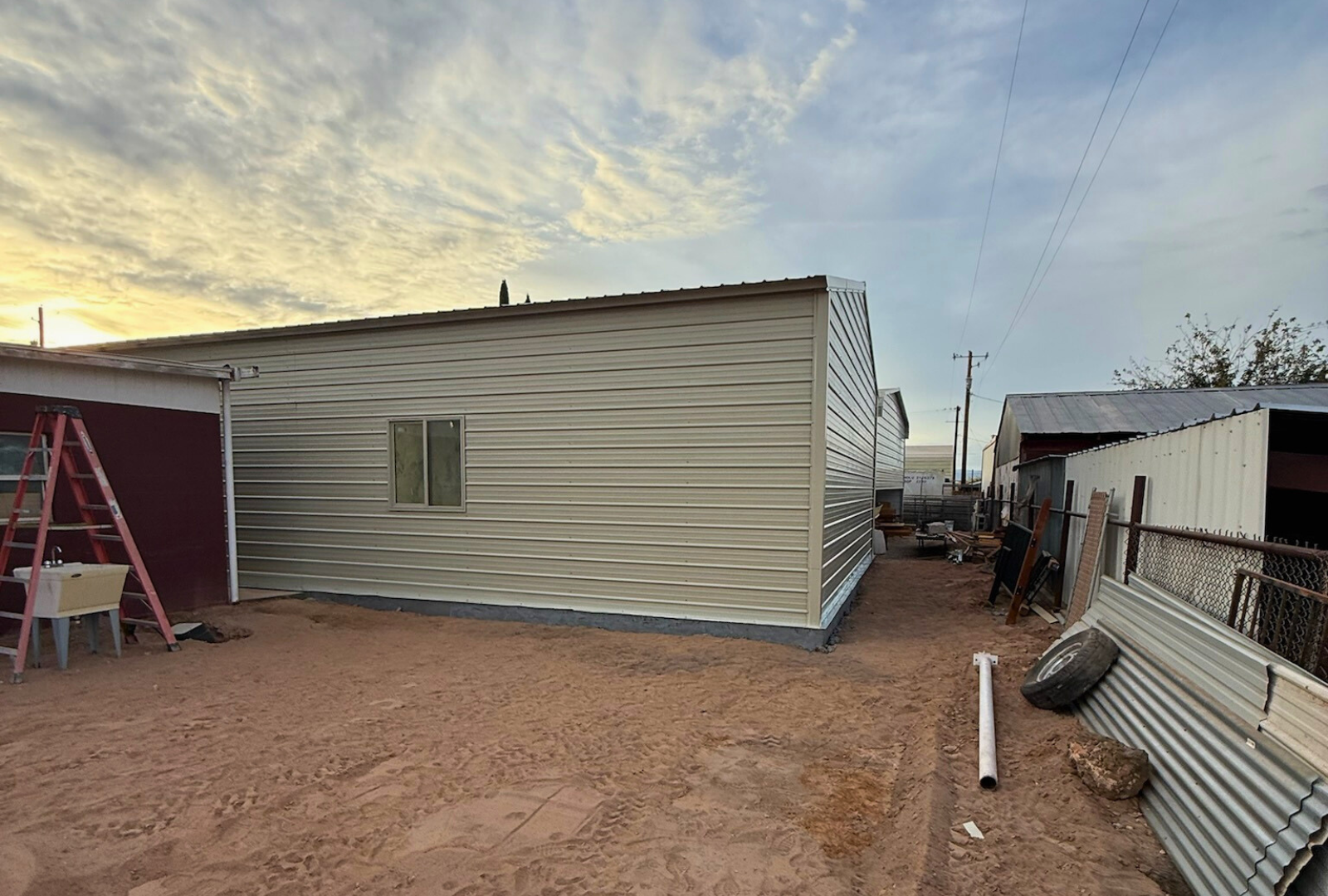 Left back angled view of a 30x45 steel building with A-frame design, vertical roof, fully closed sides and ends, and framed window openings.