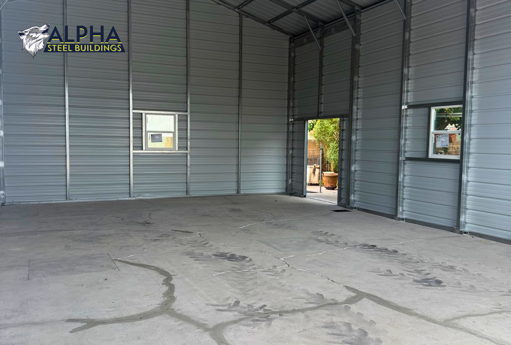 Interior of a 30'x50'x12' continuous roof barn style steel building featuring a spacious open floor plan, vertical roof, enclosed walls, walk-in door, and window.