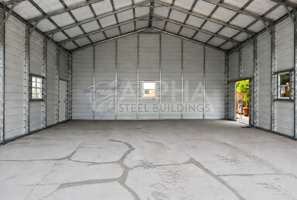 Interior of a 30'x50'x12' continuous roof barn style steel building featuring a spacious open floor plan, vertical roof, enclosed walls, walk-in door, and window.