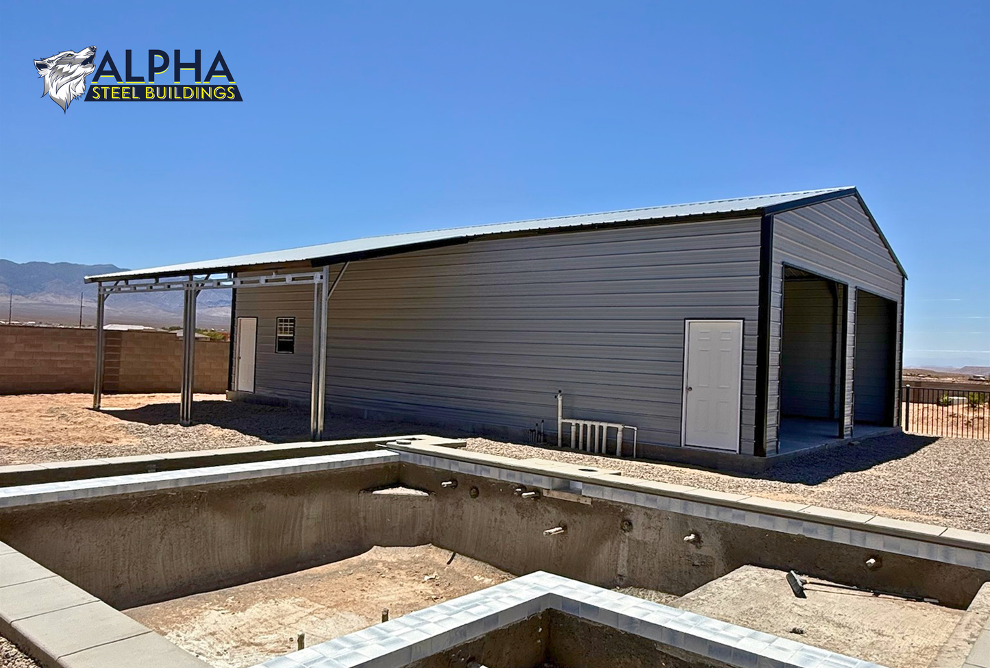 Exterior view of a 30'x50'x12' continuous roof barn style steel building with a 12'x30' attached lean-to, vertical roof, enclosed walls, overhead door openings, and walk-in doors.