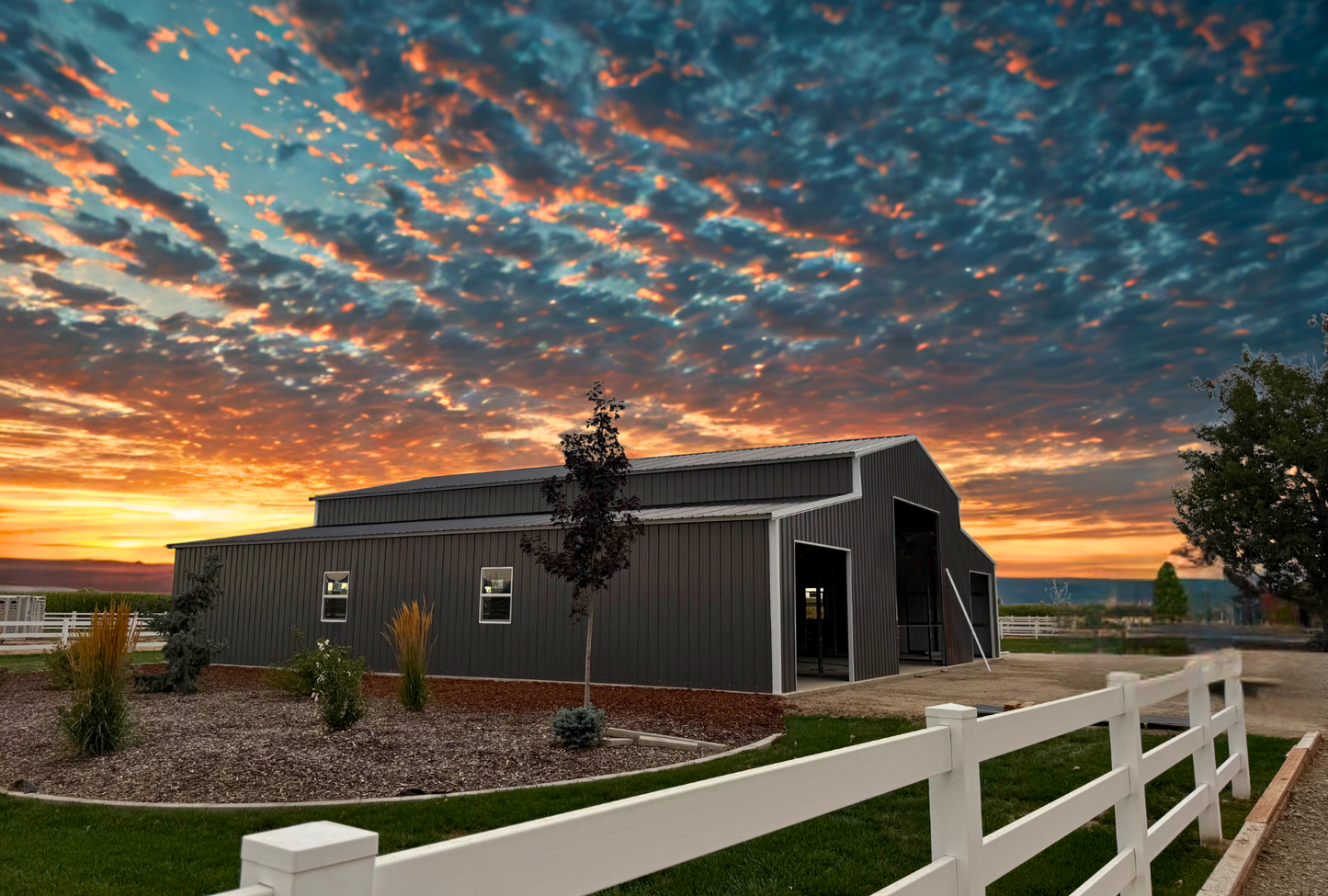30x60 A-frame barn style steel building with 16-foot height, vertical roof, two 15-foot wide 60-foot long lean-tos, overhead doors, windows, and walk-in doors, engineered for 60 PSF ground snow load, front left side angled view.