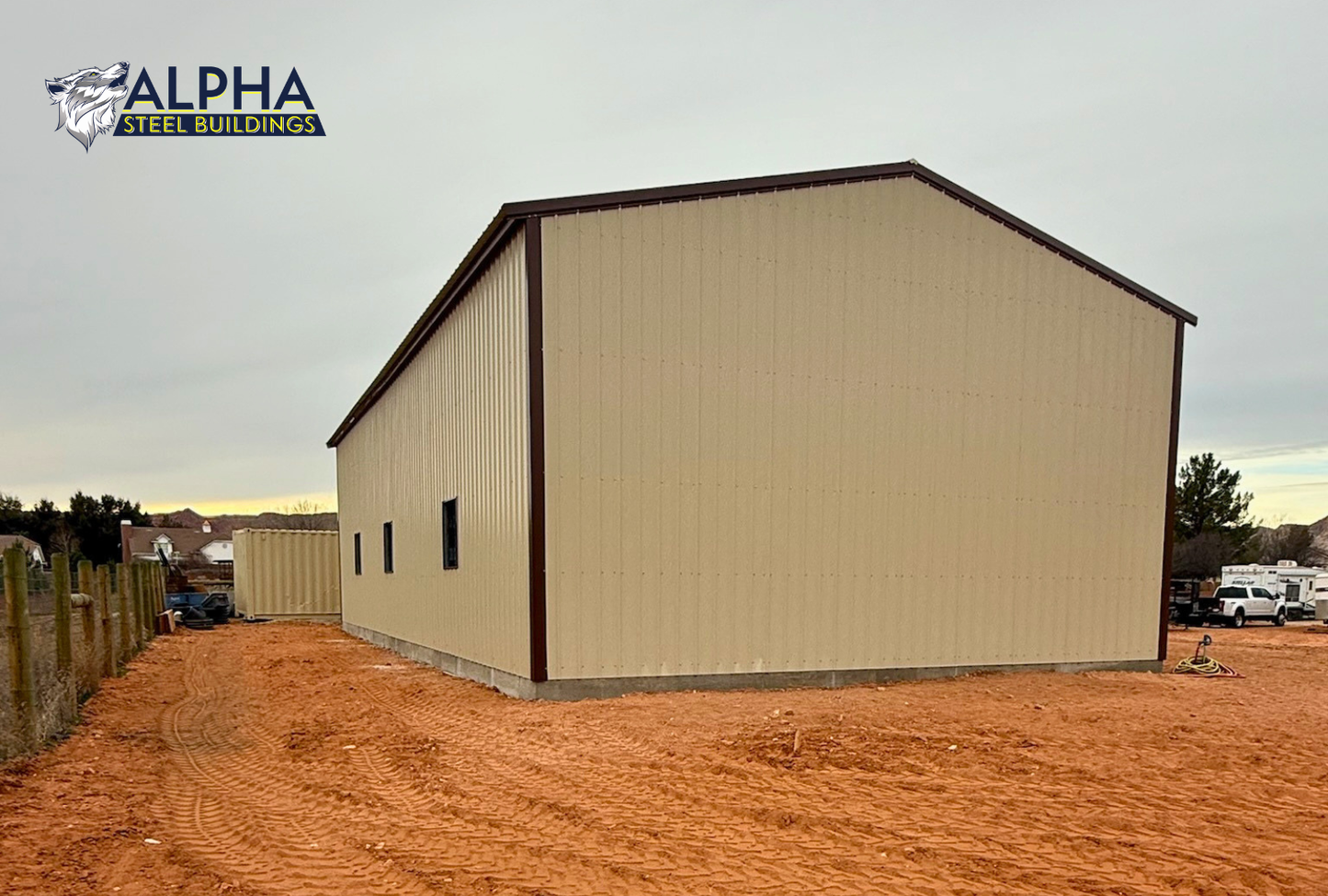 Front left angled view of 30x60x15 A-frame steel garage with vertical roof showing side wall with window frame-outs and enclosed front end.