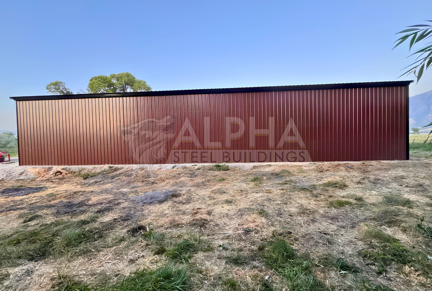 Side view of a 36x80x14 ladder style A-frame steel agricultural building showing the fully enclosed 80-foot side with vertical metal panels.