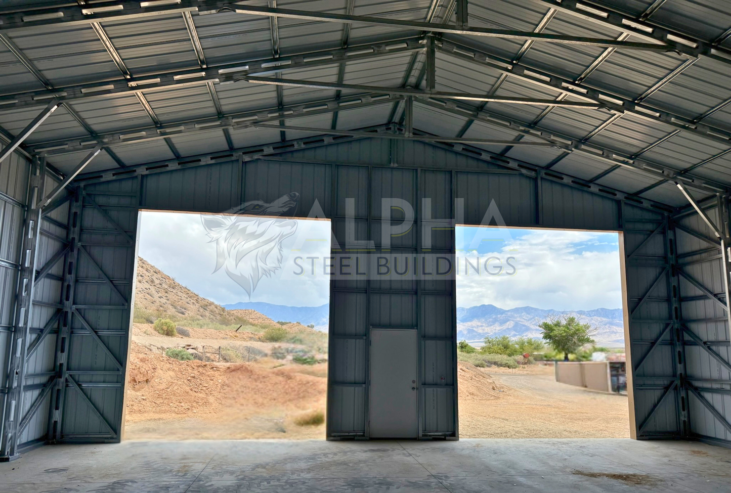 Internal front view of 40'x40'x15' steel shop features ladder style truss design, vertical roof, fully enclosed with vertical siding, one 36" x 80" walk-in door, and two 12' x 14' overhead door frame outs on the end. 