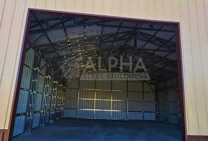 Close up front view of 56'x45'x14' clear span building with main section & dual lean-tos. Features web truss design, vertical roof, 14 Ga. frame, 40PSF ground snow load, fully enclosed with vertical siding, one walk-in door, and frame outs for one 12' x 12' overhead door and one 10' x 10' overhead doors on the front end.