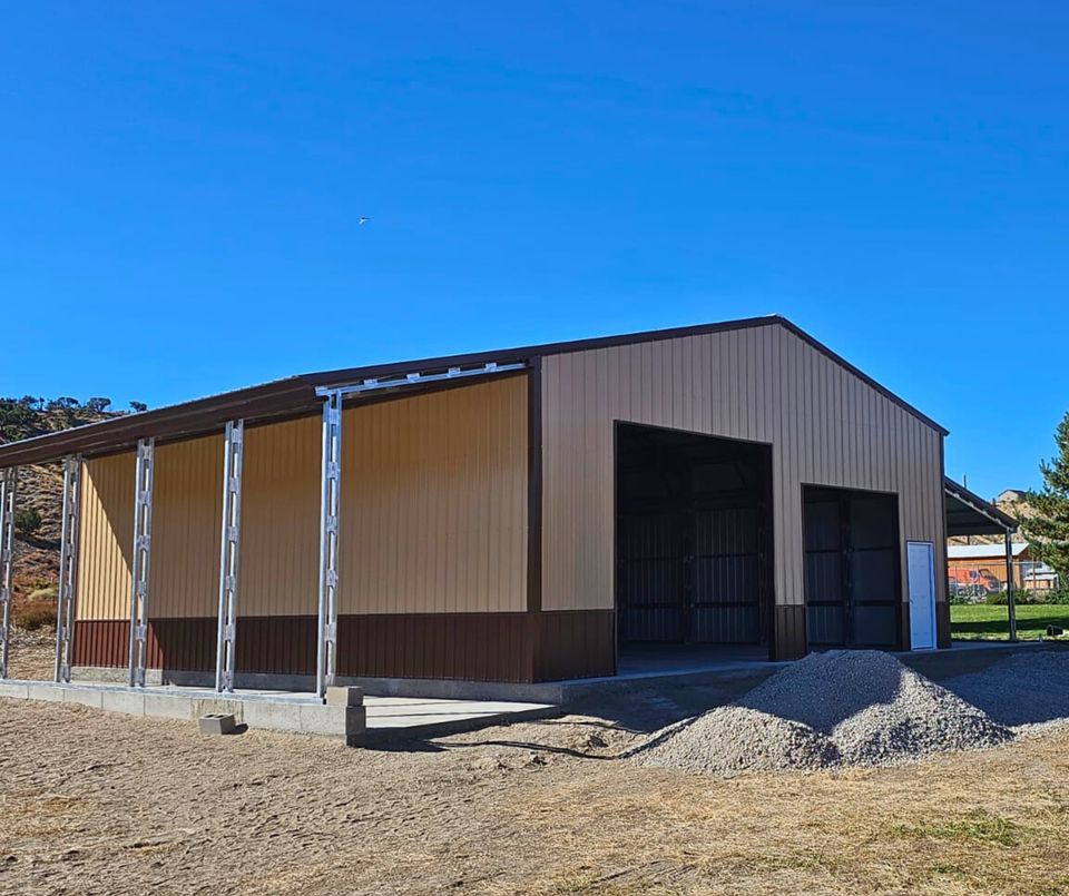 56'x45'x14' metal building with main section 36'W x 45'L x 14'H, left lean-to 10'W x 45'L x 14'-11'6"H, right lean-to 10'W x 45'L x 10'-7'6"H. Features web truss design, vertical roof, 14 Ga. frame, 40PSF ground snow load, fully enclosed with vertical siding, one 36" x 80" walk-in door, and frame outs for one 12' x 12' and one 10' x 10' overhead doors on the front end. Includes 150 1/2" concrete bolts.