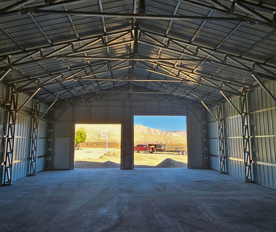 56'x45'x14' metal building with main section 36'W x 45'L x 14'H, left lean-to 10'W x 45'L x 14'-11'6"H, right lean-to 10'W x 45'L x 10'-7'6"H. Features web truss design, vertical roof, 14 Ga. frame, 40PSF ground snow load, fully enclosed with vertical siding, one 36" x 80" walk-in door, and frame outs for one 12' x 12' and one 10' x 10' overhead doors on the front end. Includes 150 1/2" concrete bolts.