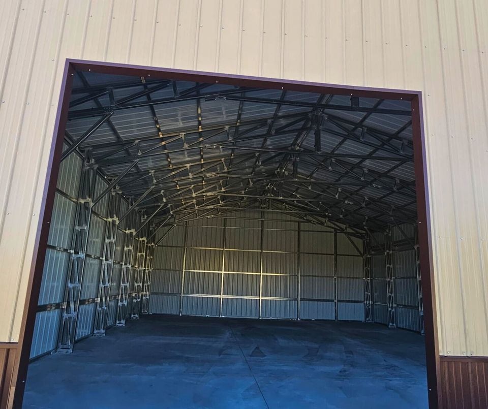 56'x45'x14' metal building with main section 36'W x 45'L x 14'H, left lean-to 10'W x 45'L x 14'-11'6"H, right lean-to 10'W x 45'L x 10'-7'6"H. Features web truss design, vertical roof, 14 Ga. frame, 40PSF ground snow load, fully enclosed with vertical siding, one 36" x 80" walk-in door, and frame outs for one 12' x 12' and one 10' x 10' overhead doors on the front end. Includes 150 1/2" concrete bolts.