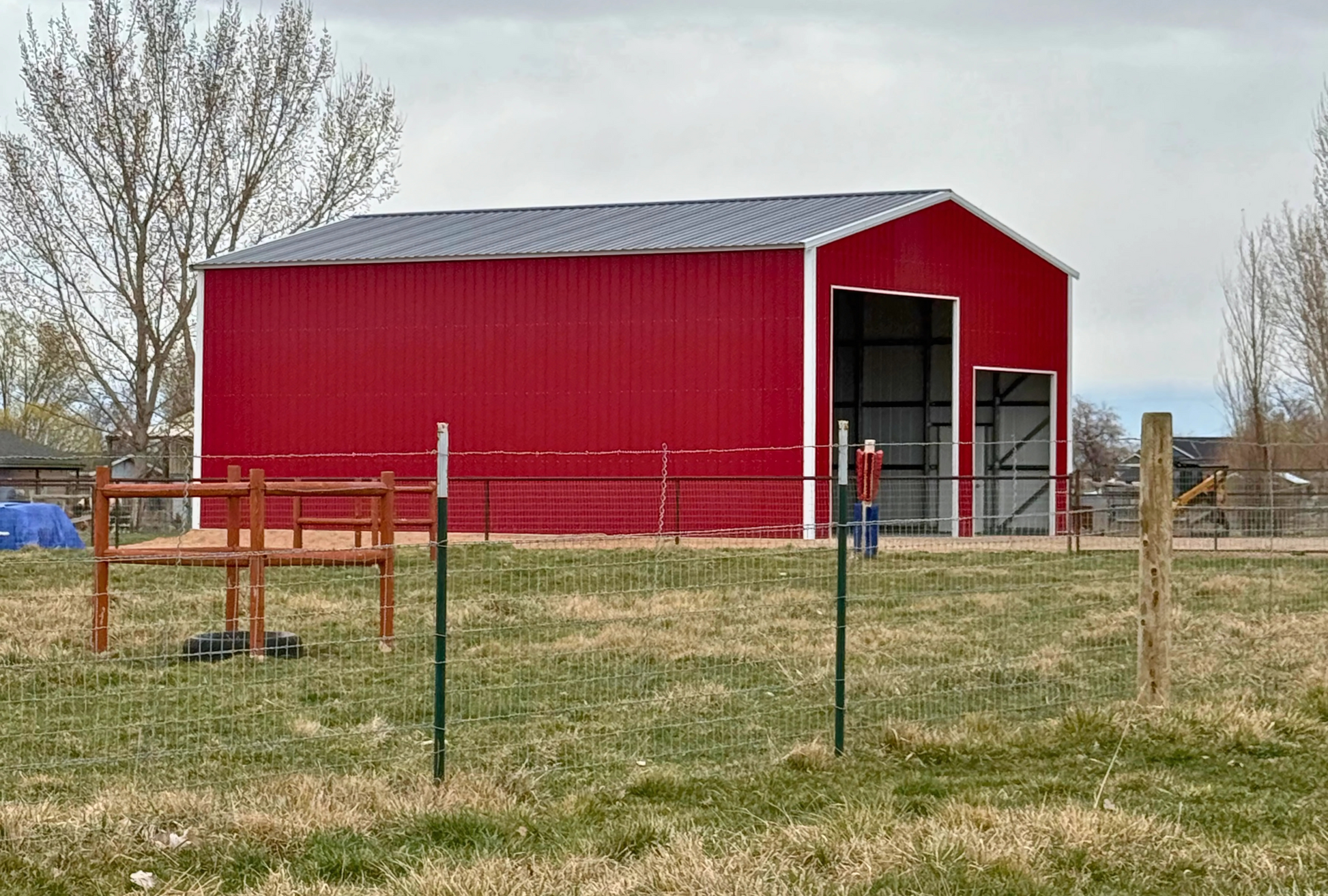 30x45x16 A-frame steel building with vertical roof, dual overhead door frame-outs, walk-in door, and closed vertical sides and ends.