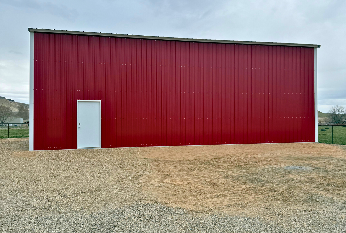 Side view of fully enclosed 30x45x16 steel building with vertical panels and double leg posts for added strength.