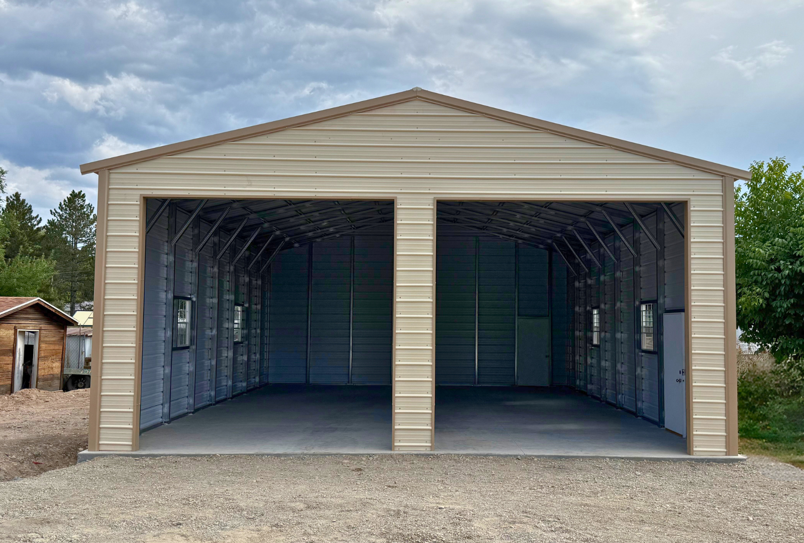 0x40x13 A-frame steel building with vertical ivory roof and saddle tan trim, enclosed sides and ends, two 12x12 overhead door frame-outs, four windows, and two walk-in doors. Built with 14-gauge framing and certified for 34 PSF snow load and 115 MPH wind load, front view.