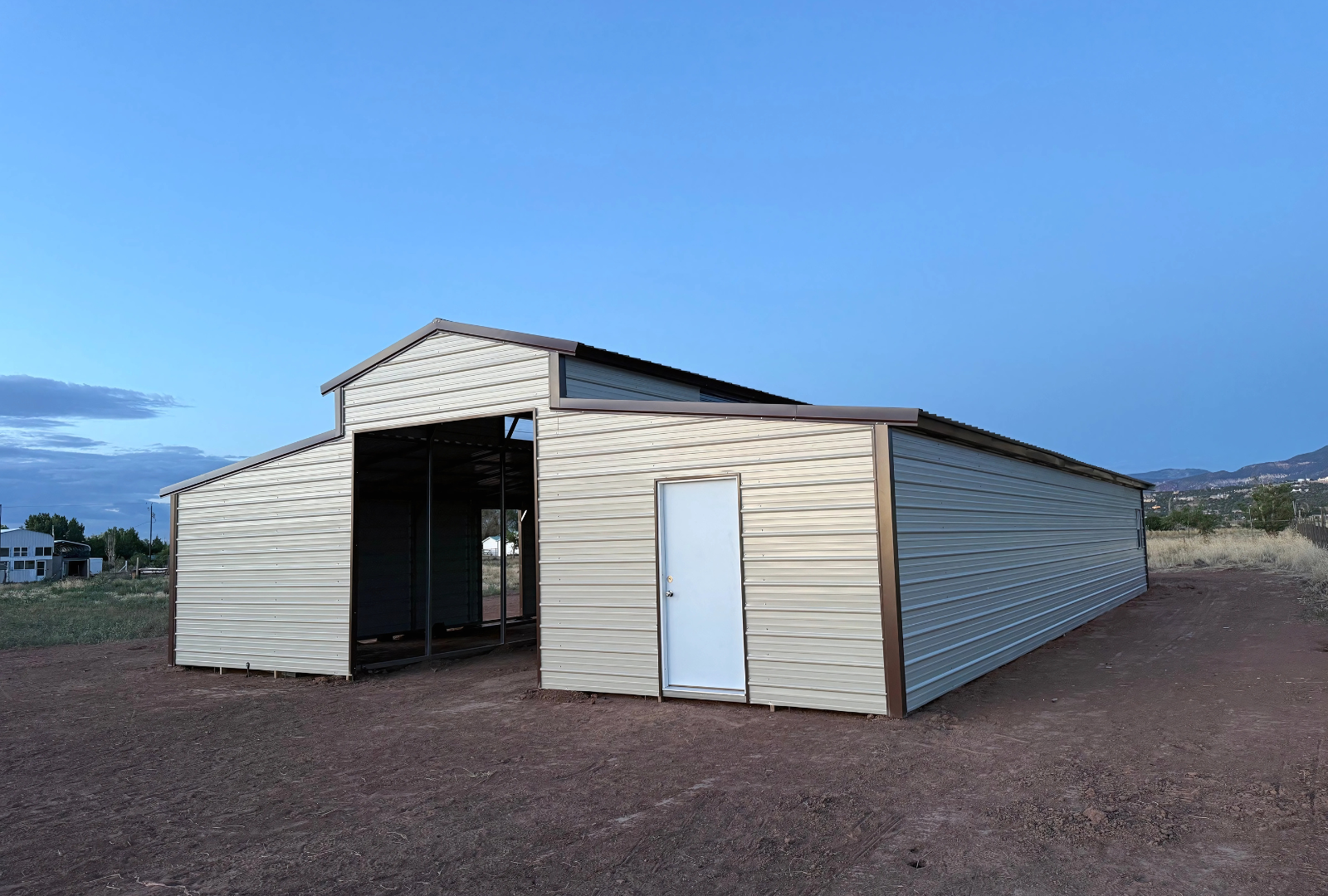 36'x60'x12' down to 10'-8' steel barn style with lean-tos, two panels under the eave, both sides closed, all ends closed, with 12' x 10' tack room, (2) 10' x 10' frame outs on the ends, (1) 10' x 10' frame out on the side of main, (4) 4' x 7' stall frame outs, (2) 30" x 36" windows, (2) 36" x 80" walk-in doors, front right view.