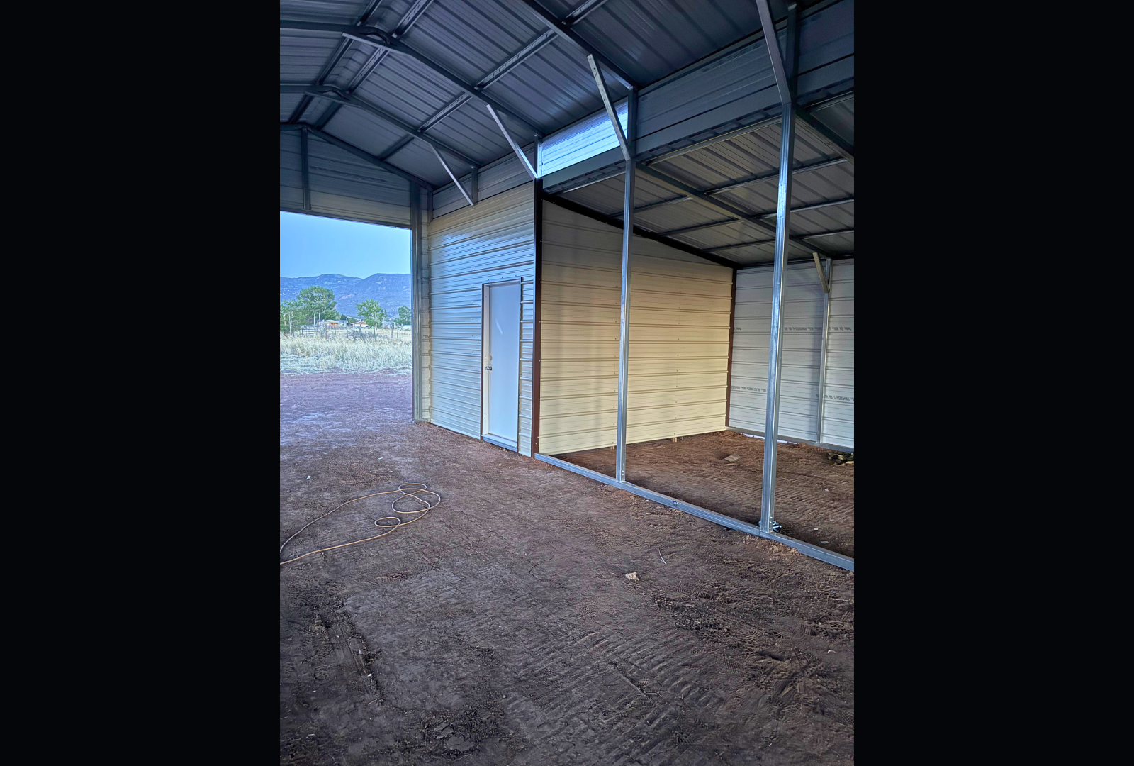 36'x60'x12' down to 10'-8' steel barn style with lean-tos, two panels under the eave, both sides closed, all ends closed, with 12' x 10' tack room, (2) 10' x 10' frame outs on the ends, (1) 10' x 10' frame out on the side of main, (4) 4' x 7' stall frame outs, (2) 30" x 36" windows, (2) 36" x 80" walk-in doors, inside view.