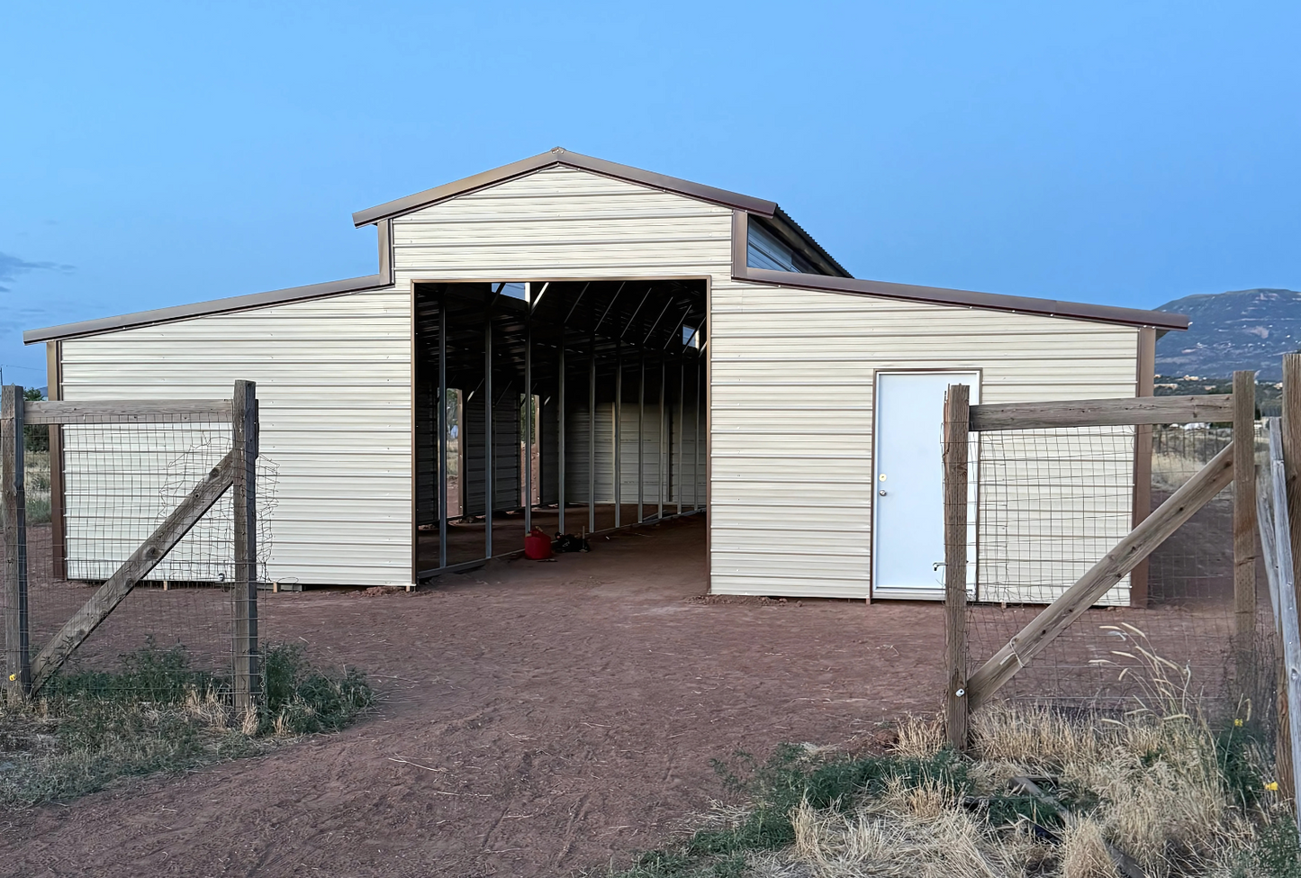 36'x60'x12' down to 10'-8' steel barn style with lean-tos, two panels under the eave, both sides closed, all ends closed, with 12' x 10' tack room, (2) 10' x 10' frame outs on the ends, (1) 10' x 10' frame out on the side of main, (4) 4' x 7' stall frame outs, (2) 30" x 36" windows, (2) 36" x 80" walk-in doors, front view.