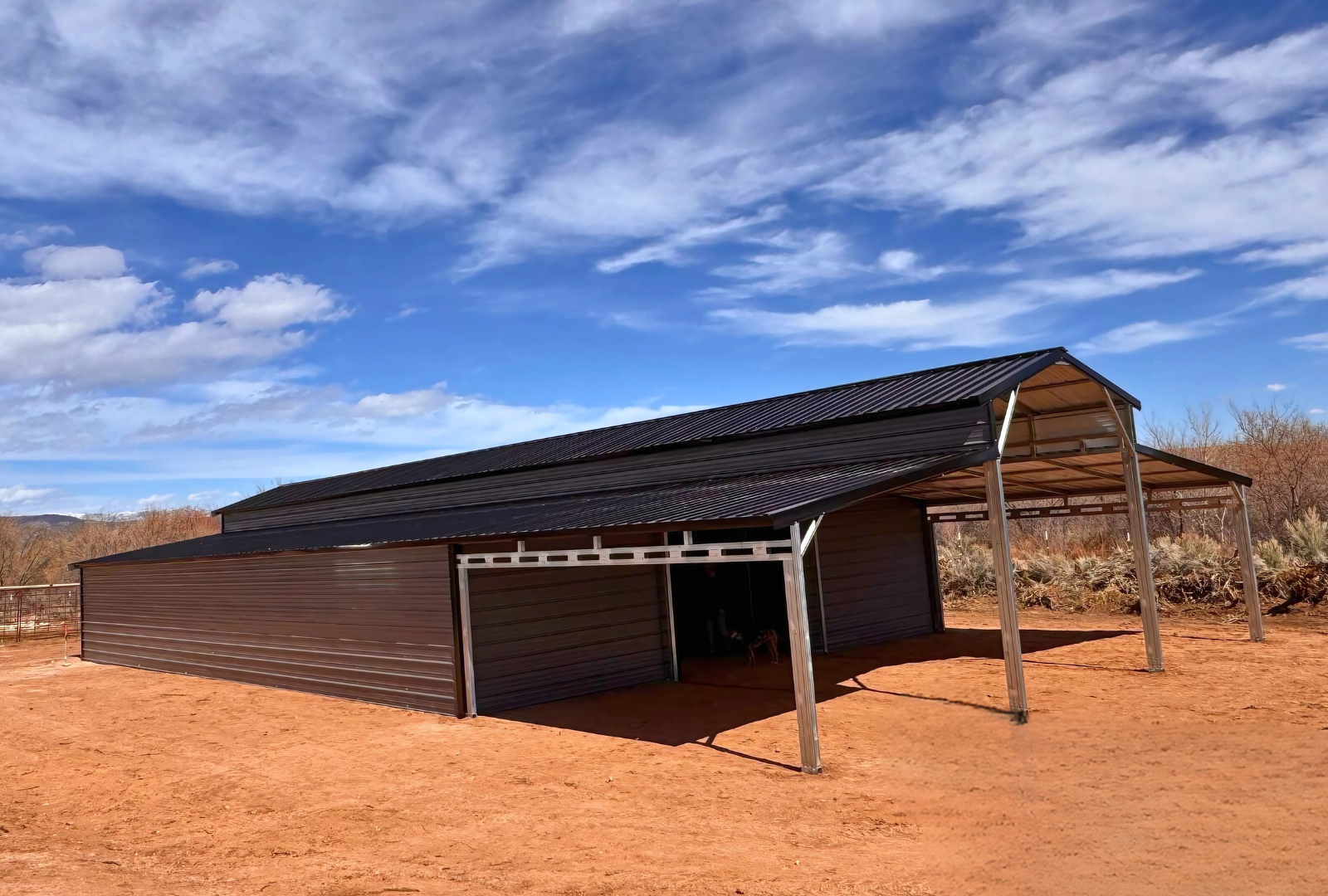 36'x80'x12' down to 10'-8' steel barn with lean-tos, two panels under the eave, both sides closed @ 60'L, all ends closed & front porch, front left view.