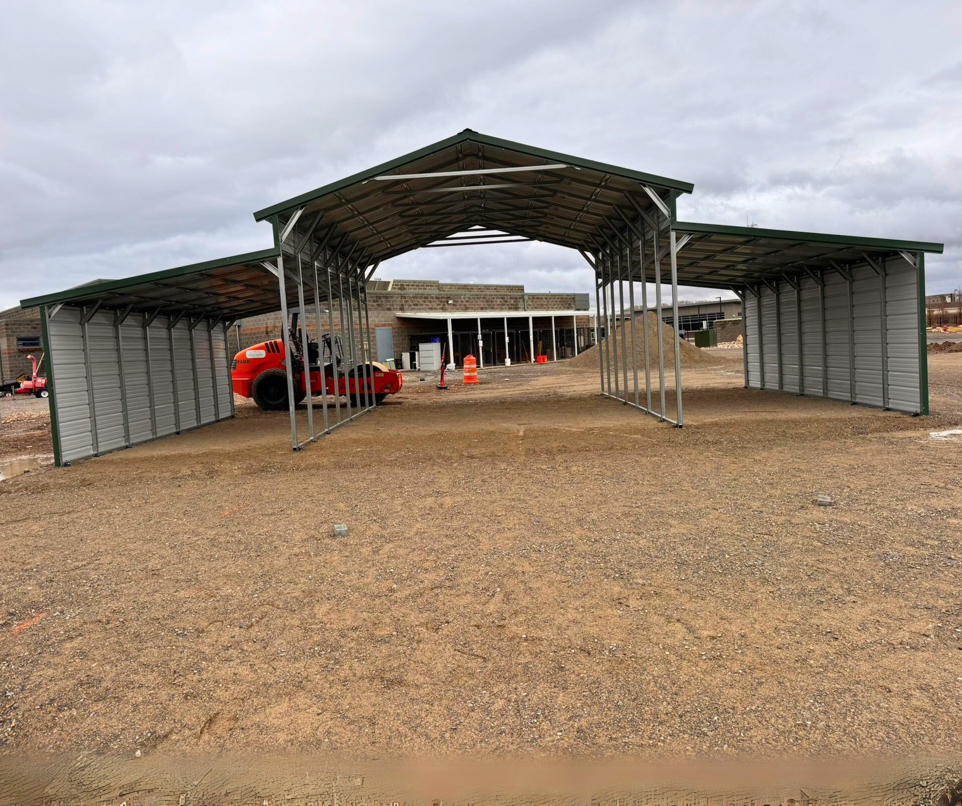 44'x25'x12' down to 10'-8' steel barn with lean-tos, two panels under the eave and closed on both sides.