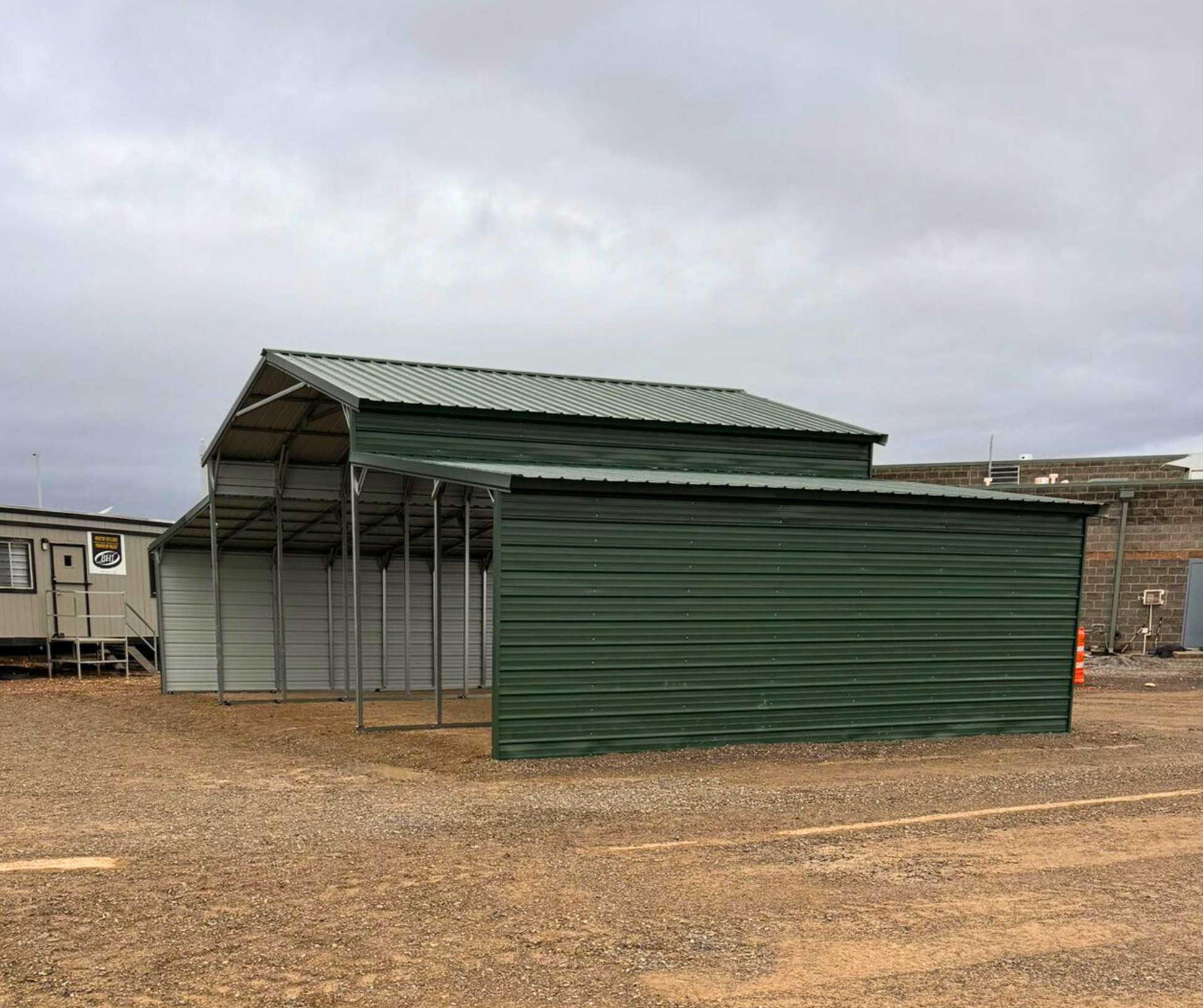 44'x25'x12' down to 10'-8' steel barn with lean-tos, two panels under the eave and closed on both sides.