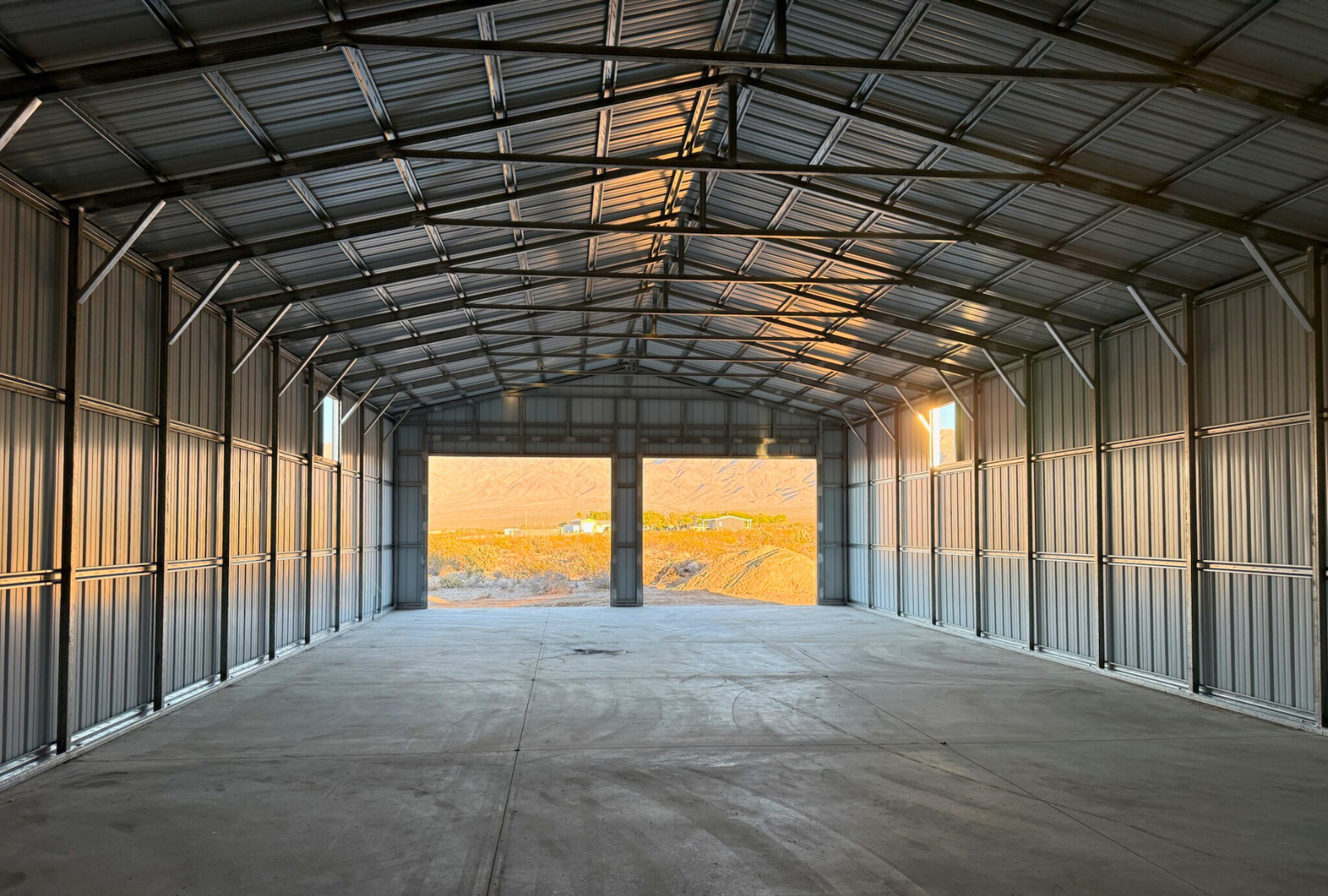 Interior view from rear to front of a 30x80 A-frame steel structure by Alpha Steel Buildings, highlighting durable framing, vertical panels, and open floor space.